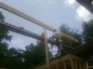 Carpenter setting a ridge beam over a new addition frame — Ice Dam Removal by Roofing Brothers in Roaring Spring