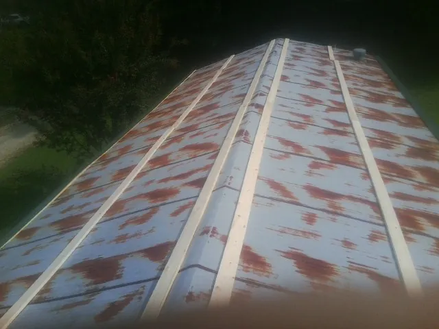 Rusted metal roof panels with new wood purlins before replacement — Storm Damage Roof Repair in Roaring Spring by Roofing Brothers