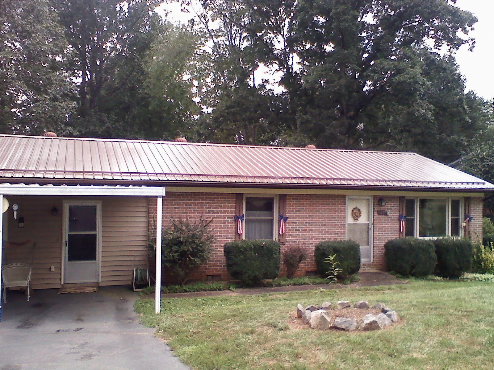 Bronze metal roof and carport on a brick ranch home — Roof Repair work by our crew in Roaring Spring